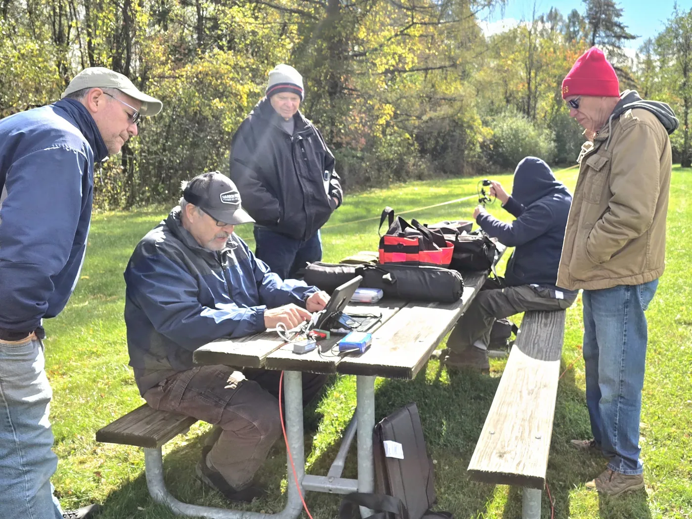 Club members gather around a portable station at a picnic table at Moraine State Park